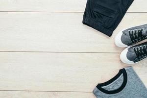 T-Shirt mit Hosen und Schuhen auf hölzernem Hintergrund foto