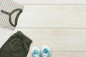 T-Shirt mit Hosen und Schuhen auf hölzernem Hintergrund foto