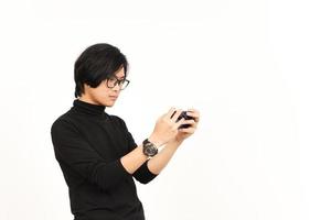 spielen Handy, Mobiltelefon Spiel auf Smartphone von gut aussehend asiatisch Mann isoliert auf Weiß Hintergrund foto