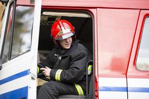 ein Feuerwehrmann ist Sitzung im ein Feuer LKW. foto