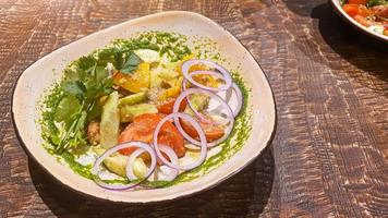 Diät Salat von frisch Gemüse. Kopfsalat, pochiert Ei, Tomaten, Grün Zwiebeln und Chili Pfeffer. Soße. foto