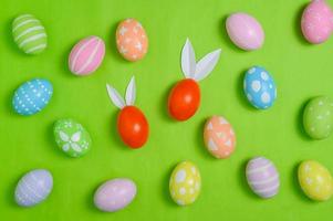 glücklich Ostern Urlaub Gruß Karte Design Konzept. bunt Ostern Eier und Frühling Blumen auf Pastell- Grün Hintergrund. eben legen, oben Sicht, Kopieren Raum. foto