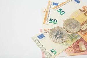 Euro und Bitcoin Banknoten, Kryptowährung und Blockchain Konzept auf Weiß Hintergrund eben legen foto