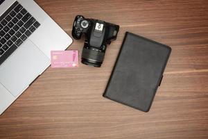 ein Laptop und ein Kamera auf ein hölzern Tabelle foto