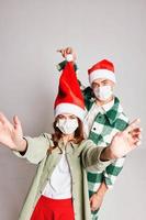 jung Paar zusammen Neu Jahre medizinisch Masken fröhlich Weihnachten Spaß foto