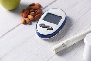 Mandeln und Messgeräte für Diabetiker auf dem Tisch foto