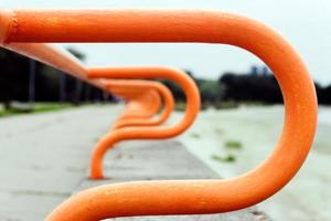 abstrakt Hintergrund. verschwommen gebogen Geländer von das Promenade gehen in das Distanz. das Metall ist gemalt orange. foto