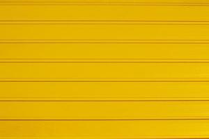 Hintergrund Textur von horizontal Gelb Tor Tafeln. breit und eng Streifen. foto