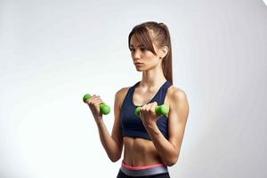 Frau halten Hanteln Stärke Übungen Fitness Muskeln foto