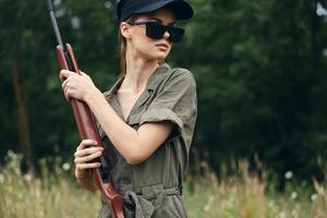 Frau auf Natur Sonnenbrille Jagd Lebensstil Waffe frisch Luft Grün foto