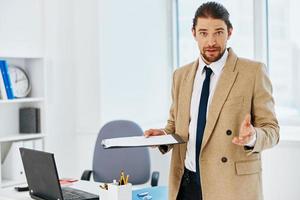 Mann im Beige Jacke offiziell Unterlagen Arbeit Büro Technologien foto