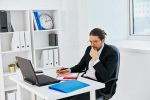 Geschäftsmann Arbeit im das Büro im Vorderseite von ein Laptop Exekutive foto