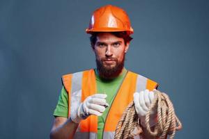 ein Mann im ein Arbeiten Uniform mit ein Seil im seine Hände Emotionen Konstruktion Lebensstil foto