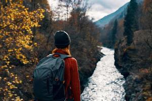 Frau Tourist mit Rucksack bewundert Natur Fluss Berge Reise foto