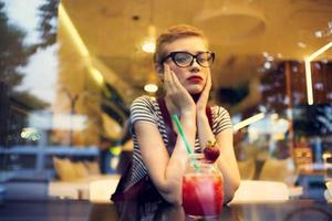 Frau mit Brille Sitzung im ein Restaurant Cocktail Ferien Einsamkeit foto