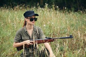 Frau Soldat im Sonnenbrille halten Waffen Schutz Lebensstil frisch Luft foto