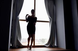 Frau Silhouette in der Nähe von Fenster Innere posieren Modell- foto