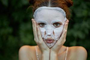 Porträt von ein Mädchen kosmetisch Maske Hände in der Nähe von das Gesicht und Augen breit öffnen nackt Schultern foto