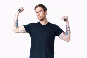 Mann mit Hanteln Muskeln Muskeln Bodybuilder Fitness und tätowieren auf seine Arm foto