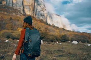 Frau Wanderer mit ein Rucksack Reisen im das Berge draußen im Herbst gefallen Blätter foto