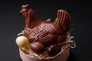 Schokolade Ostern Henne und Eier im ein Nest mit Stroh foto