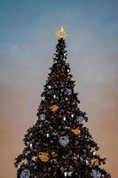 bunt Weihnachten Baum schimmernd gegen das Hintergrund von das Abend Pastell- Himmel foto