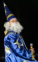 Weißrussland, das Stadt von Gomil, Dezember 10, 2019. das Urlaub von Beleuchtung das Weihnachten Baum.a Mann im ein Magier Kostüm mit ein Mikrofon. Astrologe. foto