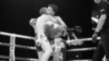 unscharfe Bilder Schwarz-Weiß-Fotostil des Thaiboxens oder Muay Thai oder Kickboxen, bei dem einheimische und ausländische Boxer auf der Indoor-Bühne als Kampfkunstsport auf dem Ring kämpfen. Muay Thai Kickboxen foto