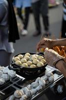 Essen Anbieter Herstellung Takoyaki, ein köstlich Straße Essen Snack beim das jogokariyan Ramadhan Markt foto