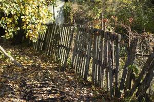 Zaun im Dorf. Zaun gemacht von Bretter. Landschaft im Herbst. foto