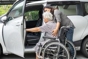 Pflegekraft Hilfe und Unterstützung asiatisch Alten Frau Sitzung auf Rollstuhl bereiten erhalten zu ihr Auto zu Reise im Urlaub. foto