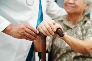 Arzt Hilfe asiatisch Alten Behinderung Frau geduldig halten Gehen Stock im faltig Hand beim Krankenhaus. foto