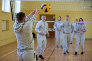 ein öffnen Lektion im das Hochschule von physisch Bildung. Menschen abspielen Volleyball im das Fitnessstudio. foto