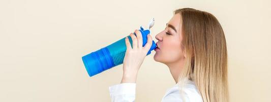 Frau Trinkwasser aus der Flasche foto