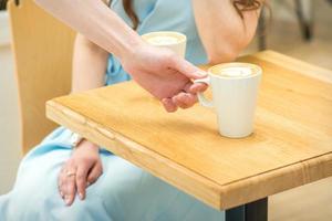 Bedienung setzt ein Tasse von Kaffee foto