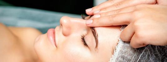 weiblich Therapeut Herstellung Stirn Massage foto