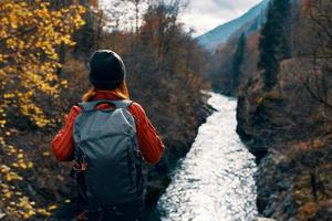 Frau Tourist mit Rucksack bewundert Natur Fluss Berge Reise foto