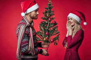 Mann und Frau Weihnachten Baum Dekoration Spaß Urlaub rot Hintergrund foto