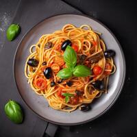 Spaghetti. Italienisch Pasta Gericht mit Tomaten, schwarz Oliven, Kapern, Sardellen und Basilikum auf dunkel Tisch. oben Sicht. generativ ai. foto