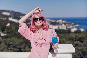 Porträt von schön Frau Trinken ein Cocktail auf das Terrasse Entspannung Konzept foto