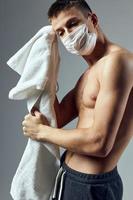 Sport Mann Tücher Schweiß mit ein Handtuch medizinisch Maske Bodybuilder trainieren foto