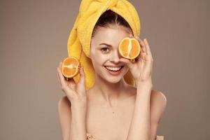 Frau mit entblößt Schultern Orangen im Hände sauber Haut Gesundheit Beige Hintergrund foto