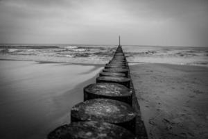 Strand Landschaft von das baltisch Meer auf ein Ruhe Tag mit ein hölzern Wellenbrecher foto