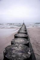 Strand Landschaft von das baltisch Meer auf ein Ruhe Tag mit ein hölzern Wellenbrecher foto