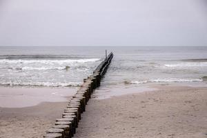 Strand Landschaft von das baltisch Meer auf ein Ruhe Tag mit ein hölzern Wellenbrecher foto