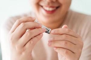 Frau Schneiden Fingernägel mit Nagel Haarschneidemaschine, Gesundheitspflege, Schönheit Konzept. foto