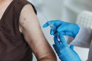 Krankenschwester macht ein Injektion im das Arm Immunität Schutz covid Reisepass Nahansicht foto