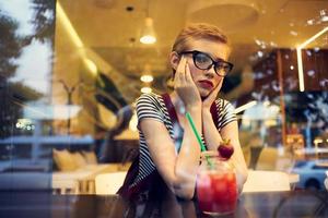 Frau mit Brille Sitzung allein im ein Cafe Cocktail Freizeit Lebensstil foto