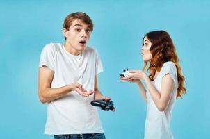 jung Paar im Weiß T-Shirts mit Joysticks im ihr Hände Video Spiele Unterhaltung foto