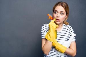 Frau halten Waschmittel im Hände Reinigung Hausarbeit Lebensstil grau Hintergrund foto